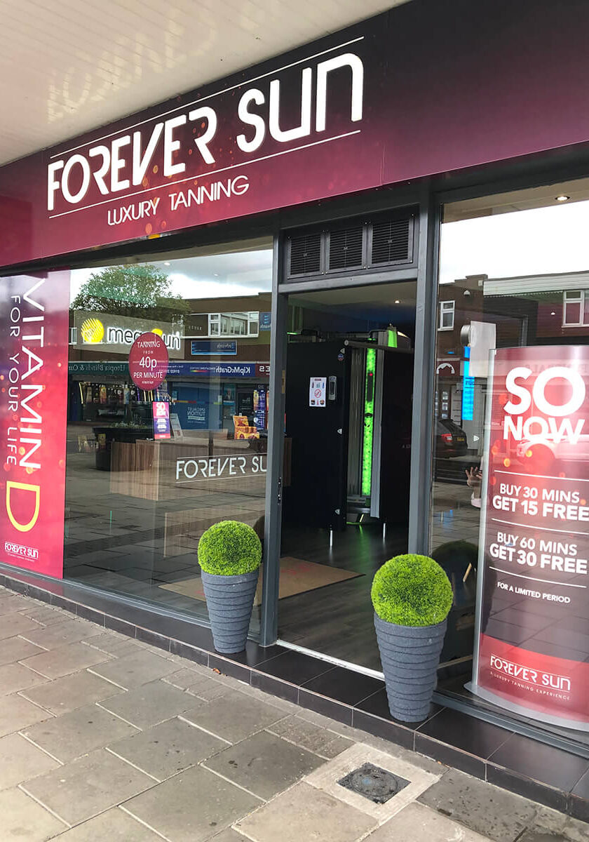 A store front with lots of windows and signs.